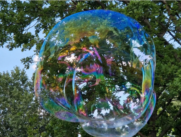 Large bubble floating in the air near trees