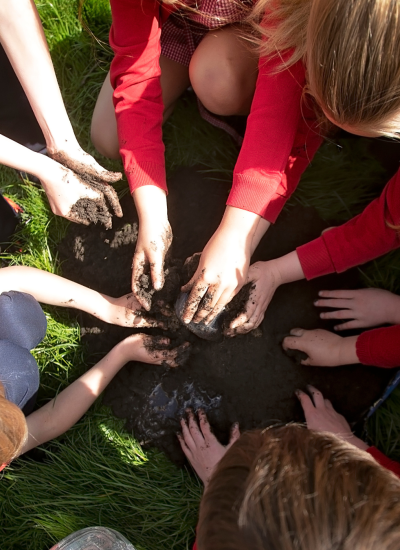 A group of children building a volcano out of mud for KS2 science