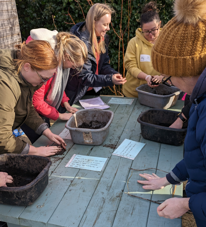 A group of teachers doing an outdoor activity with mud & an Alfresco Learning team member