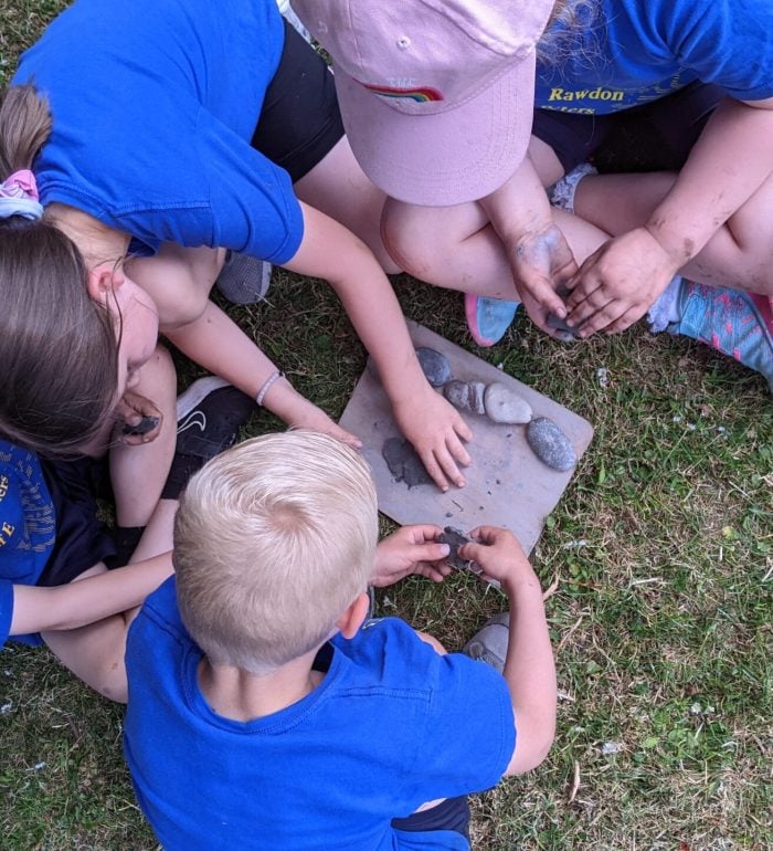 A group of children working together to build a small model outdoors