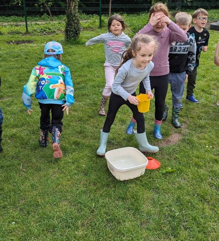 Children playing water bucket relay