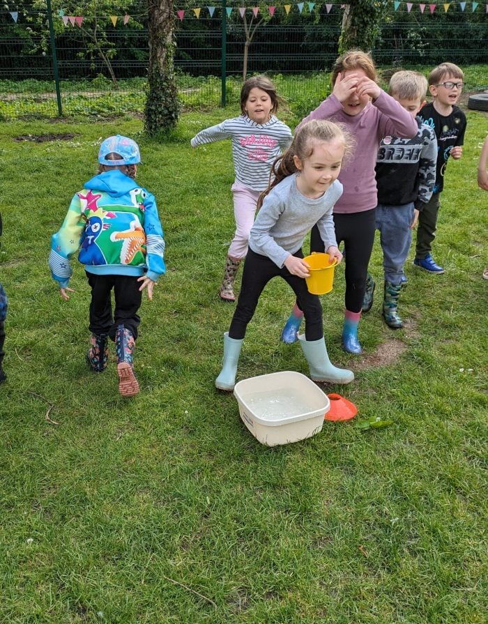Children playing water bucket relay