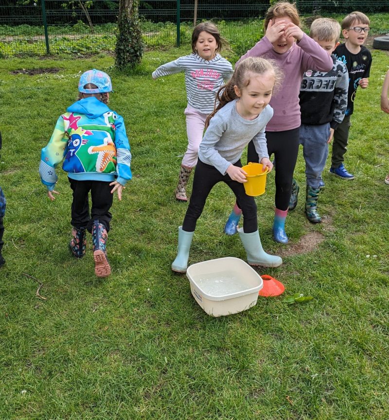 Children playing water bucket relay