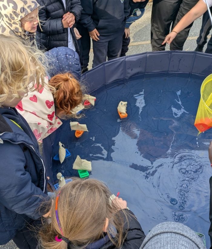 Children floating boats in a paddling pool